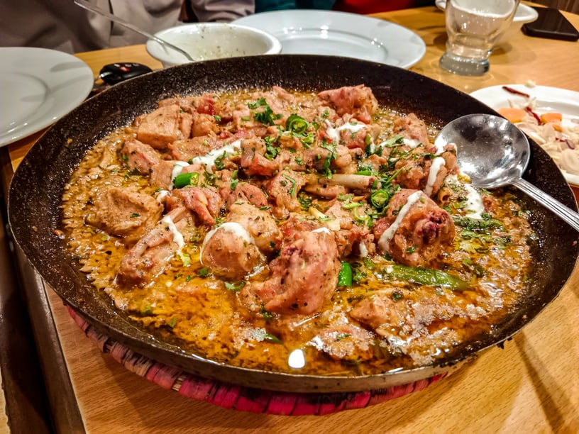 Desi butter chiken masala serverd in karahi top view of indian, pakistani karai food